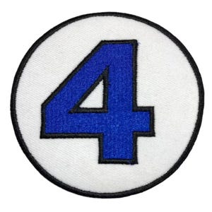 Può includere: Un cerchio bianco con un contorno nero e un numero quattro blu al centro.