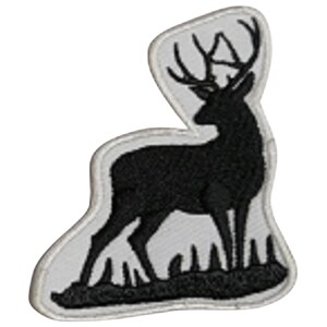 May include: Black embroidered patch of a deer silhouette standing in a field of grass. The patch is on a white background.