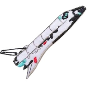 May include: White felt space shuttle patch with black, red and blue details. The patch has a loop on the back for attaching.