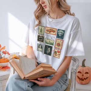 Vintage Twilight stamp shirt featuring retro postage-style graphics inspired by the Twilight saga, including Forks Washington, classic red truck, vampire fangs, wolves, apple, and chess piece. Printed on premium Comfort Colors or Gildan cotton tee for a soft and durable fit. Perfect gift for Twilight fans, book lovers, or movie marathon nights. Cozy fan apparel with aesthetic retro vibes, ideal for everyday casual wear or as a unique fandom collectible shirt.