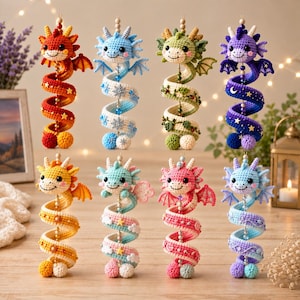 May include: Eight crocheted dragon ornaments arranged in two rows. Each dragon features a round head with small horns and wings, attached to a long, spiraling tail decorated with various small motifs like stars, snowflakes, leaves, and moons.