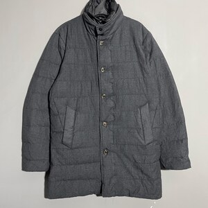 May include: A gray quilted puffer jacket with a button closure and a stand-up collar.