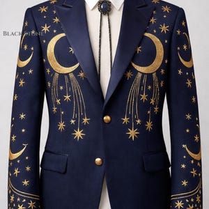 May include: Navy blue blazer with gold embroidered celestial design featuring moons and stars. The blazer has a satin lapel, gold buttons, and is paired with a bolo tie. A white collared shirt is visible underneath.
