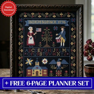 May include: Framed cross-stitch sampler with a dark background, featuring patriotic imagery. The design includes figures, an American flag, a tree, an eagle, a church, and the text "INDEPENDENCE 1776". The frame is dark brown, and the sampler has a floral border.