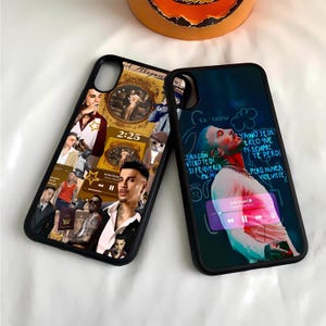 May include: Two black phone cases with different designs. The first case features a collage of images, including a man with a microphone, a clock, and a cat. The second case features a blue and pink background with a man's face and text in Spanish. The text reads "Corazón vitro te di si te quería pn-m Yano sedr creo que pasicmpre te perdí pero nunca volviste".