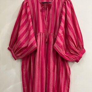 ​Artisanal midi dress with gathering at waist and cuffs.