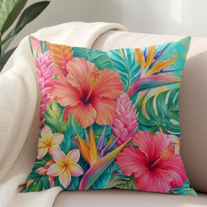 May include: A square throw pillow featuring a vibrant tropical print with large orange and pink hibiscus flowers, yellow and purple bird of paradise blooms, white plumeria, and pink ginger flowers set against a background of lush green palm leaves.