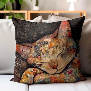 May include: Decorative square pillow featuring a colorful, artistic rendering of a sleeping cat. The cat's fur is a mosaic of warm colors, including orange, red, and gold, with intricate patterns. The background is a dark, textured pattern.