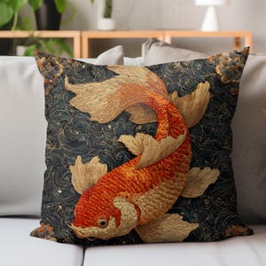 May include: Decorative square pillow featuring a detailed illustration of a koi fish. The fish is primarily orange and white, set against a dark blue background with swirling patterns. The pillow has a textured appearance, suggesting a fabric or embroidered design.
