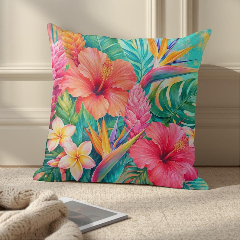 May include: A square throw pillow featuring a vibrant tropical print with large orange and pink hibiscus flowers, yellow plumeria blossoms, purple ginger stalks, and bird of paradise flowers set against a background of lush green palm leaves.