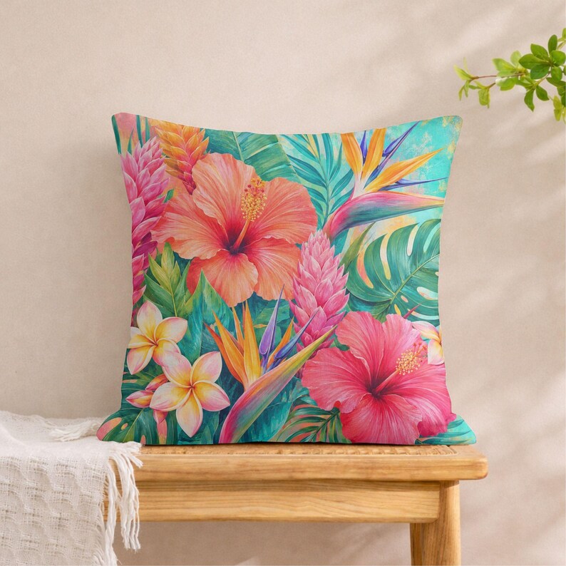 May include: A square throw pillow featuring a vibrant tropical print with large orange and pink hibiscus flowers, yellow plumeria blossoms, bird of paradise flowers, and various green palm leaves set against a bright turquoise background.