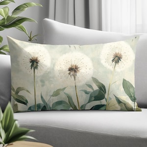 May include: A rectangular throw pillow featuring a printed illustration of three white dandelion seed heads on long stems with green leaves. The background is a soft, muted, pale green and off-white wash, creating a botanical scene.