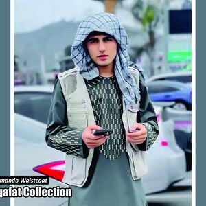 Könnte beinhalten: Eine Person trägt eine grau-weiße Commando-Weste über einem langärmeligen Hemd mit geometrischem Muster. Die Person trägt auch eine Kopfbedeckung. Der Text "Commando Waistcoat" und "Saqafat Collection" ist sichtbar.