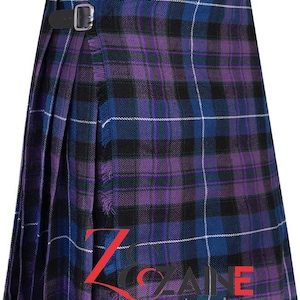 Op de afbeelding: Een paars, zwart en blauw geruite kilt met twee zwarte leren riemen en gespen. De kilt heeft een geplooid ontwerp en een gefranjerde rand. De tekst "Zane Enterprises" is zichtbaar aan de onderkant.