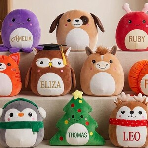 May include: A selection of plush toys in diverse forms, such as an octopus, cat, owl, dog, horse, pumpkin, penguin, Christmas tree, and reindeer. Each toy is a different colour and has a name embroidered on it.