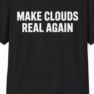 May include: Black t-shirt with the white text "MAKE CLOUDS REAL AGAIN" across the chest. The short-sleeved shirt is made of a soft material and is suitable for casual wear.