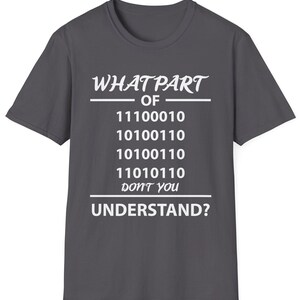 Puede incluir: Camiseta gris oscuro con texto blanco. El texto dice "WHAT PART OF" seguido de c&oacute;digo binario y "DON'T YOU UNDERSTAND?" Un dise&ntilde;o humor&iacute;stico para programadores y entusiastas de la tecnolog&iacute;a.