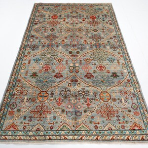 May include: A blue and beige rug with a traditional Persian design. The rug features intricate floral and geometric patterns in shades of red, green, and blue.