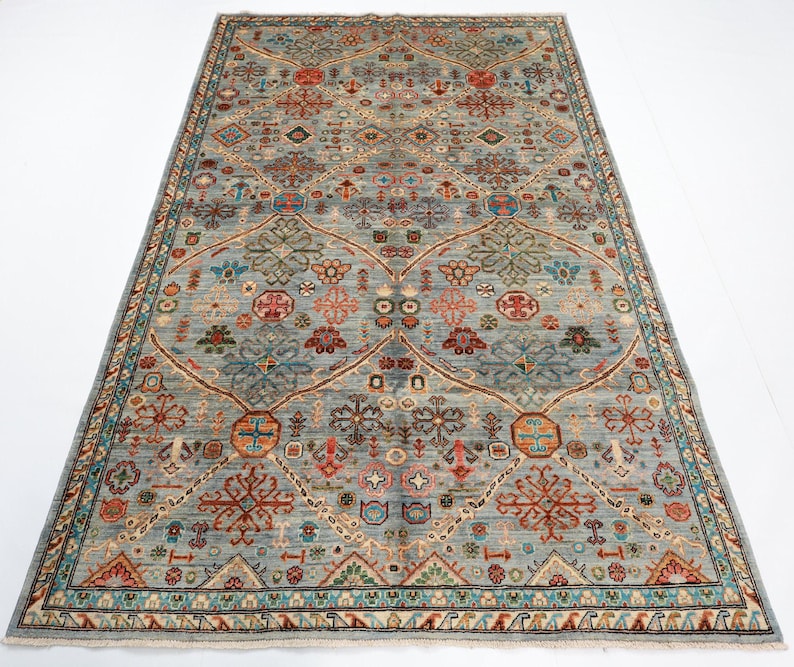 May include: A blue and beige rug with a traditional Persian design. The rug features intricate floral and geometric patterns in shades of red, green, and blue.