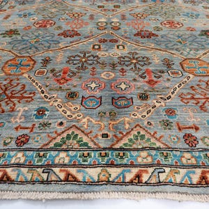May include: A blue and red patterned rug with a geometric design. The rug has a fringe border and is made of wool.