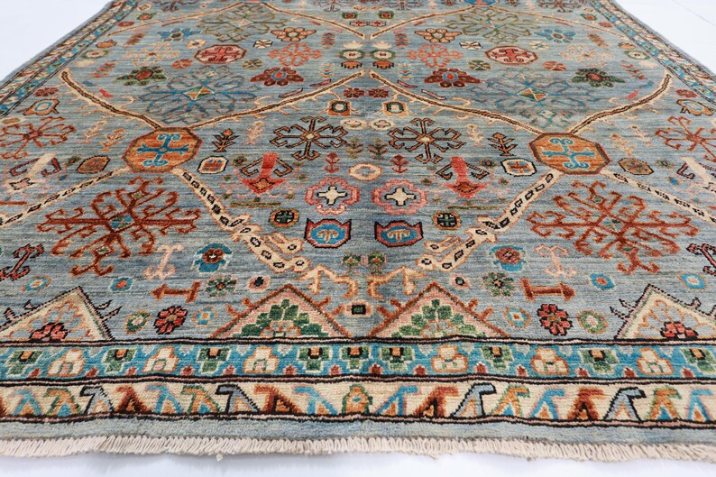 May include: A blue and red patterned rug with a geometric design. The rug has a fringe border and is made of wool.