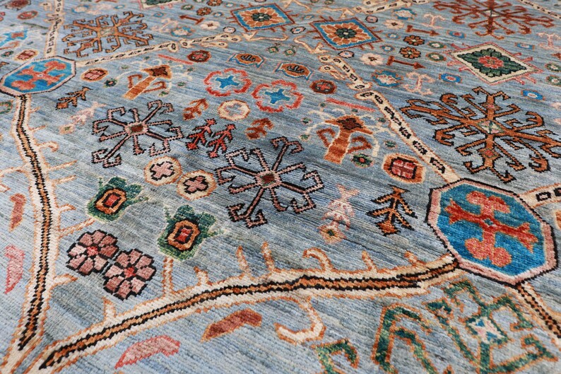 May include: A blue rug with a traditional Persian design featuring intricate patterns of flowers, stars, and geometric shapes in shades of red, orange, green, and brown.