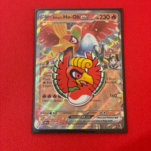 May include: A Pokémon trading card featuring Ho-Oh EX. The card has a red, yellow, and white Ho-Oh illustration. The card also includes text such as "Ethan's Ho-Oh EX" and "230 HP".