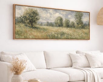 May include: A rectangular landscape painting in a wooden frame. The artwork depicts a field of tall grass and wildflowers under a cloudy sky. Several trees are scattered across the field. The color palette includes greens, yellows, and blues.