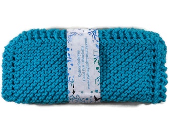 May include: A turquoise blue knitted dishcloth with a white label that reads "SydneyKathryns Hand Knit Dishcloths www.sydneykathryns.etsy.com"