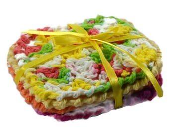 May include: A stack of colourful crocheted squares tied together with a yellow ribbon. The squares are made in a variety of colours, including pink, orange, yellow, green, and white.