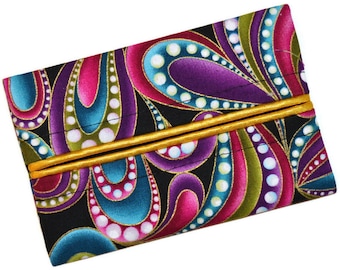 May include: A black fabric tissue holder with a colourful paisley pattern in shades of pink, purple, teal, and green. The holder has a gold trim around the edges.