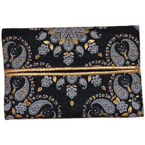 May include: A black tissue box cover with a gold paisley pattern. The cover has a gold trim around the edges.