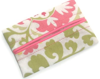 May include: A white tissue box cover with a pink and green floral pattern. The cover has a pink fabric trim and is made of a soft, textured fabric.