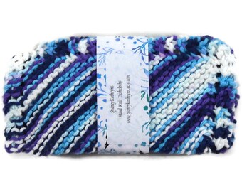 May include: A hand-knitted dishcloth in a blue, purple and white striped pattern. The dishcloth is packaged with a label that reads "Sydney Kathryns Hand Knit Dishcloths www.sydneykathryns.etsy.com"