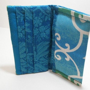 Cubierta de chequera, cartera, portatarjetas, agua oscura, pergaminos/remolinos de color azul turquesa y blanco