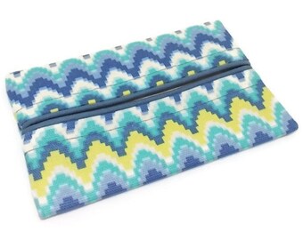 May include: A tissue box cover with a blue, green and yellow patterned design. The cover has a geometric design with a wavy pattern.