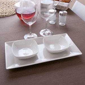 Peut inclure: Un plateau de service rectangulaire blanc avec deux bols carrés blancs. Le plateau est sur une nappe brune.