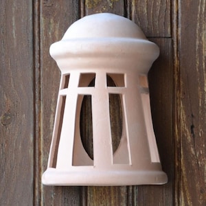 Puede incluir: Un accesorio de luz de terracota con una parte superior en forma de cúpula y un diseño de celosía decorativo. El accesorio es de color rosa claro y tiene un estilo rústico, de granja.