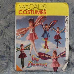 May include: A McCall's Costumes sewing pattern for Sky Dancers costumes. The pattern features illustrations of children in fairy-like outfits with wings, dresses, and tights. The pattern size is small (3,4) and petite.