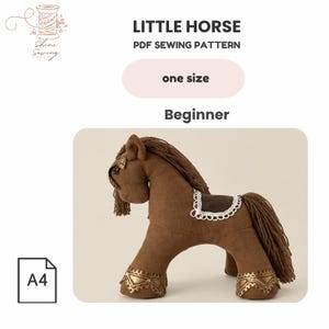 May include: A PDF sewing pattern for a little horse, labeled as one size and beginner level. The image shows a brown plush horse toy with a dark brown mane and tail, a white lace-trimmed saddle, and gold decorative accents on the hooves and head.