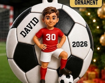 May include: A 3D acrylic ornament shaped like a soccer ball featuring a cartoon boy in a red jersey with the number 30, white shorts, and black cleats. The text DAVID is printed on the left, 2026 on the right, and 3D ACRYLIC ORNAMENT at the top.