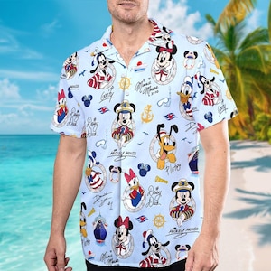 May include: Light blue button-down shirt featuring a repeating pattern of Disney characters in nautical attire. The design includes Mickey Mouse, Minnie Mouse, Donald Duck, Goofy, and Pluto, along with nautical elements like anchors and ships.