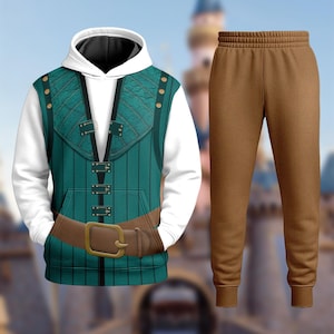 May include: A two-piece outfit comprising a white hoodie with a teal vest design and brown sweatpants. The hoodie features a detailed vest print with gold-coloured buttons and a brown belt. The sweatpants are a solid brown colour.