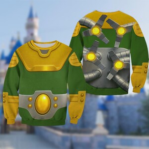 May include: Green and gold sweatshirt with a detailed design. The front features a gold chest plate and belt, while the back showcases mechanical arms with glowing yellow lights. The sleeves are yellow with gold accents. A unique and eye-catching design.