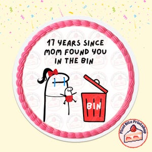 Puede incluir: Una tarta redonda con glaseado rosa y el texto "17 YEARS SINCE MOM FOUND YOU IN THE BIN". La tarta presenta una ilustración de dibujos animados de una madre y un niño con un cubo de basura rojo. La tarta tiene un fondo amarillo con confeti.