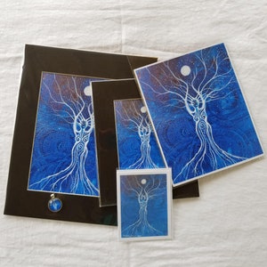 May include: A set of four framed prints featuring a white tree with a blue background. The prints are in different sizes and are framed in black.