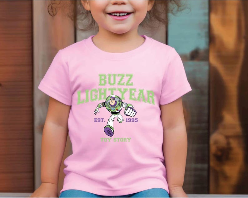 a young girl wearing a pink buzz lightyear t - shirt