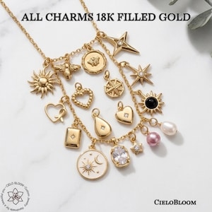 May include: A gold-tone chain necklace featuring various charms including a sun, bee, stars, hearts, a moon, and pearls. The text ALL CHARMS 18K FILLED GOLD is visible at the top, and the CIELOBLOOM logo is at the bottom. The charms include clear stones.