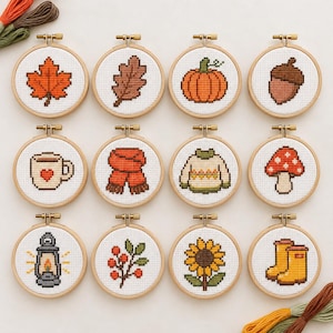 Puede incluir: Doce bastidores de bordado circulares de madera con diseños de punto de cruz con temas otoñales, que incluyen una hoja de arce, hoja de roble, calabaza, bellota, taza, bufanda, suéter, hongo, linterna, bayas, girasol y botas de lluvia amarillas.