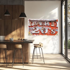 May include: Framed wall art featuring the text "DAHIL 20'S" in illuminated, vintage-style lettering. The sign has a distressed, weathered appearance with a red and blue background, mounted in a white frame. The artwork is displayed in a modern kitchen setting.